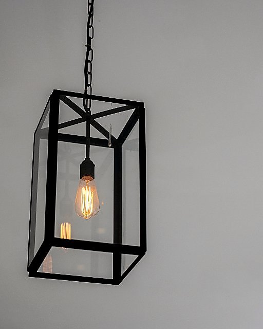 Geometric pendant light glowing against a plain wall