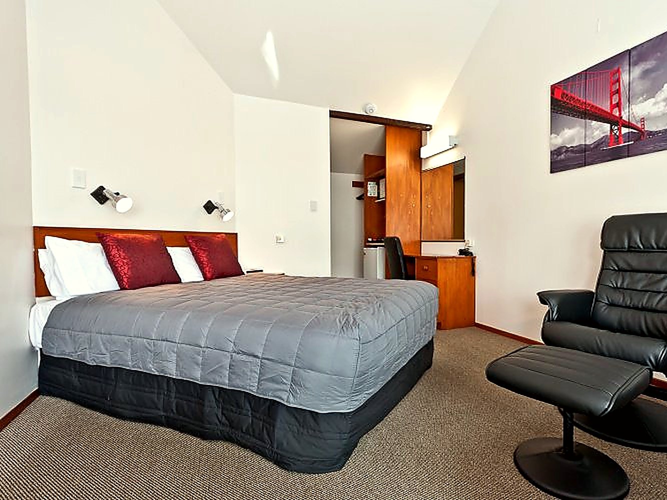 Studio unit with a queen bed, recliner chair and side table