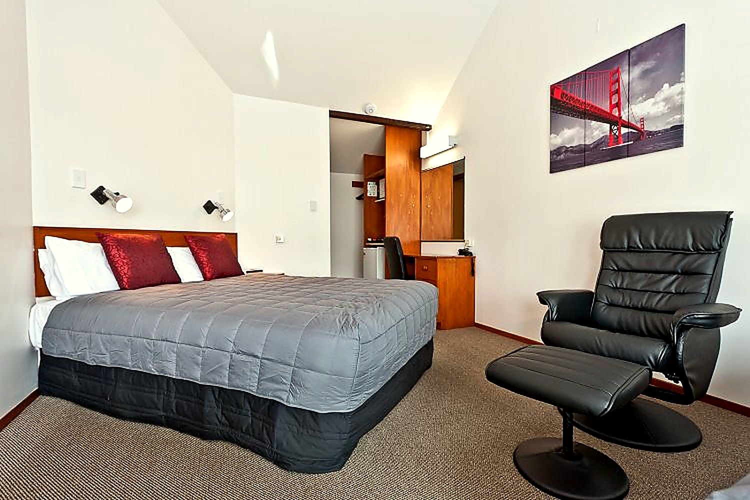 A refurbished studio unit with a bed, recliner chair and kitchenette
