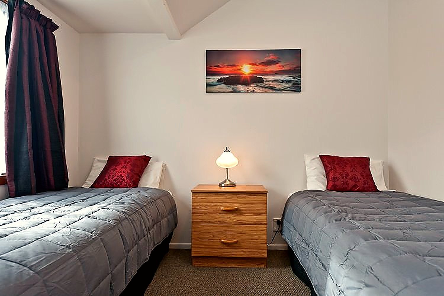 Two single beds with matching red cushions