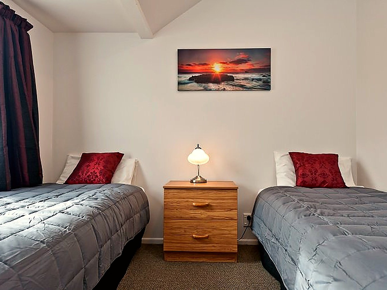 Queen and single beds made up in a refurbished studio