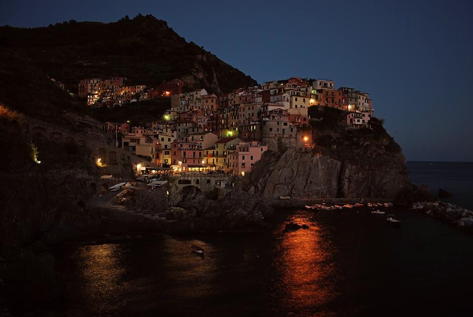 A coastal village lit at dusk