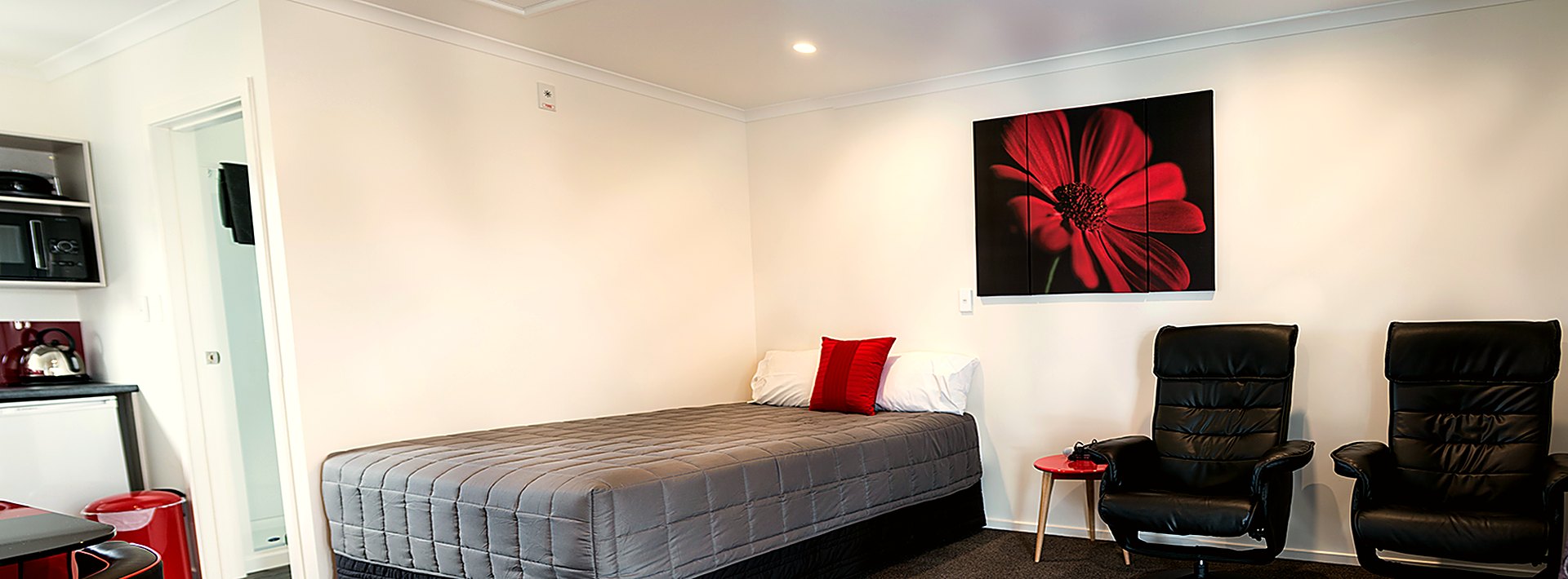 Refurbished Gateway MotorLodge interior with recliner seating and a television