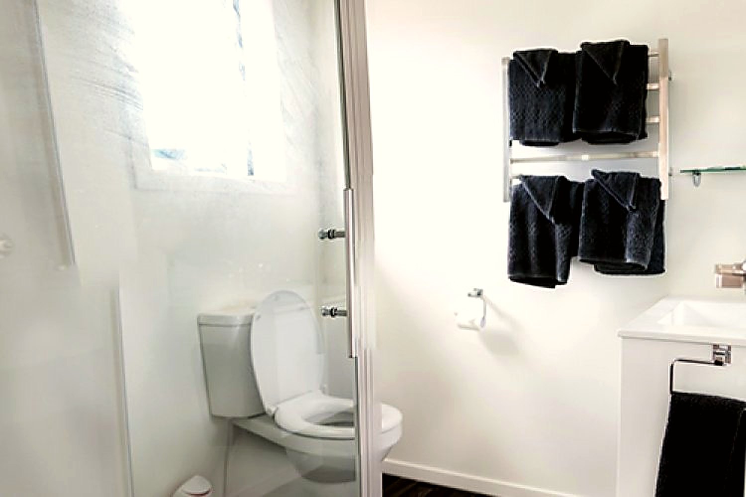 Refurbished bathroom with shower, vanity and folded towels