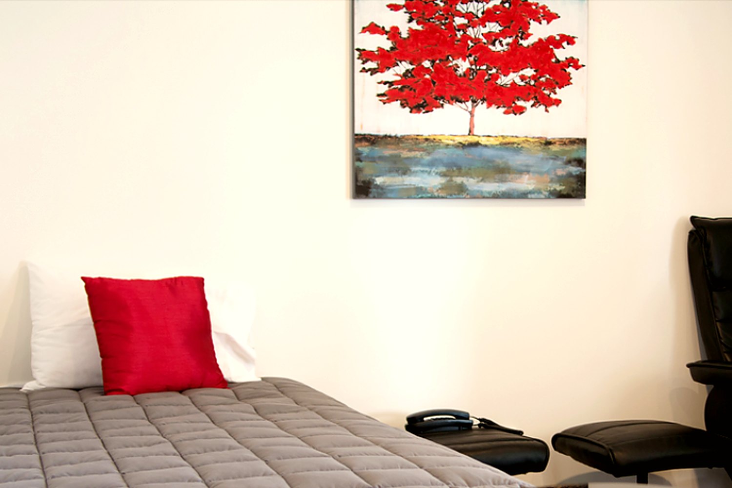 Wide view of a refurbished studio with a bed and recliner