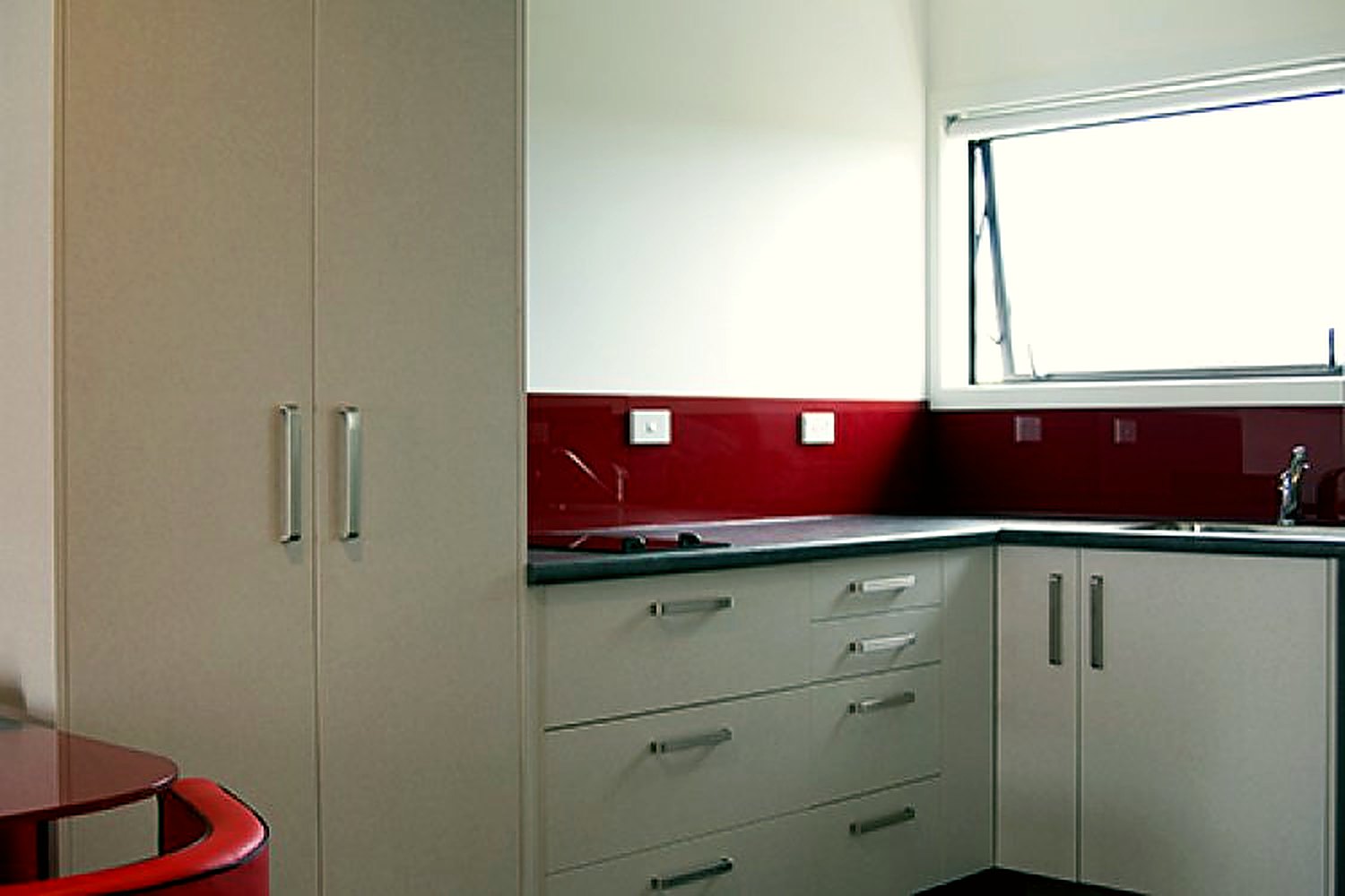 Kitchenette with bench, sink and fridge